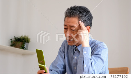 操作功能手機時遇到麻煩的老人 操作功能手機時遇到麻煩的老人 78177192