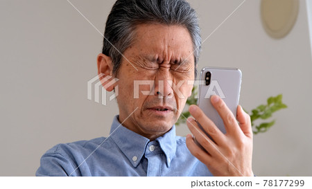 因老花眼而看不清智慧型手機的老人 因老花眼而看不清智慧型手機的老人 78177299