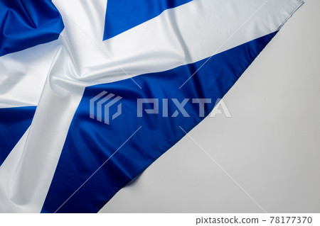Rippled flag of Scotland lying on white surface Rippled flag of Scotland lying on white surface 78177370