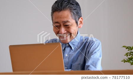 Senior man enjoying surfing the internet 78177510