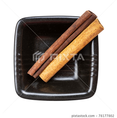 two sticks of cassia cinnamon in bowl isolated two sticks of cassia cinnamon in bowl isolated 78177802