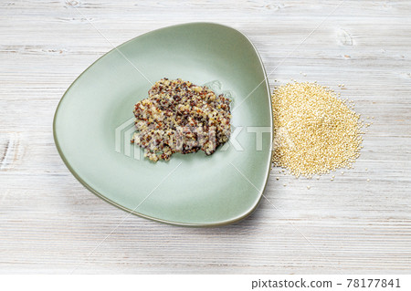 quinoa grains and boiled porridge on green plate 78177841