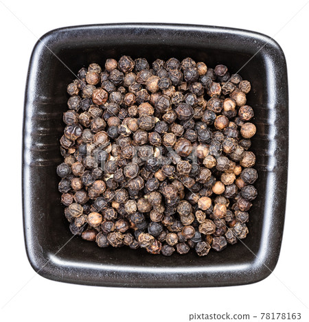 black pepper peppercorns in black bowl isolated 78178163
