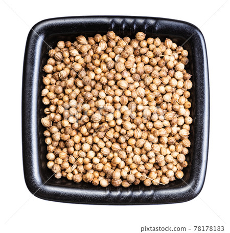 dried coriander seeds in black bowl isolated 78178183