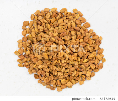 pile of whole fenugreek seeds close up on gray pile of whole fenugreek seeds close up on gray 78178635