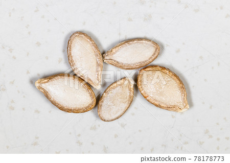 several whole pumpkin seeds close up on gray several whole pumpkin seeds close up on gray 78178773