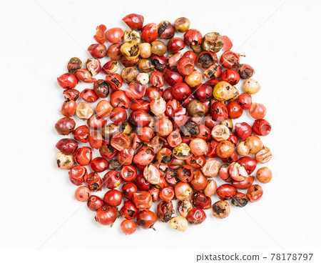 pile of pink peppercorns (Baie rose) on gray 78178797