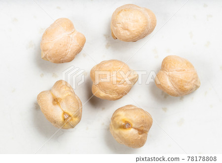 several raw dried chickpea seeds close up on gray 78178808