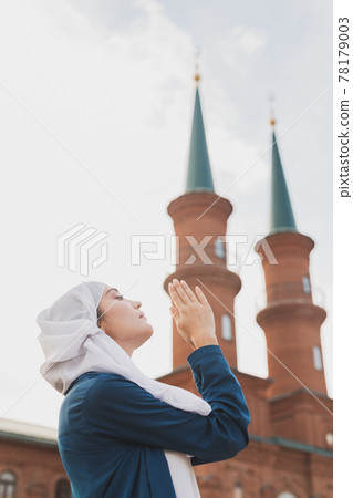 Muslim woman prayer wear hijab fasting pray to allah on mosque background Muslim woman prayer wear hijab fasting pray to allah on mosque background 78179003