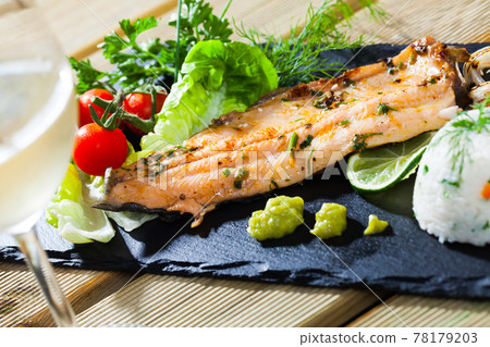 Baked trout fillet with rice, vegetables and white wine 78179203