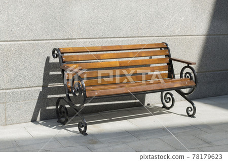 Empty wooden bench among concrete in the sunny day. Light and shadow 78179623