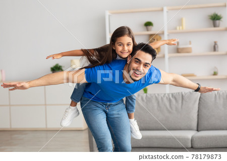Cheerful Man Riding Excited Daughter On His Back Cheerful Man Riding Excited Daughter On His Back 78179873