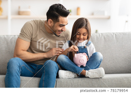 Little girl and dad saving money in piggy bank 78179954