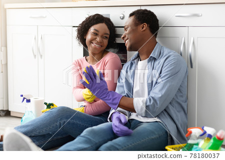 Smiling black man and woman house-keepers giving high five Smiling black man and woman house-keepers giving high five 78180037