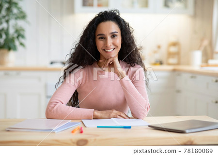 Work From Home. Smiling Beautiful Female Freelancer Sitting At Table In Kitchen 78180089