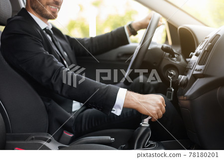 Unrecognizable businessman holding hand on gear, driving car 78180201