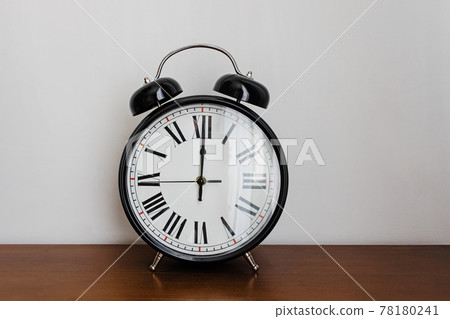 Vintage analog alarm clock on the wooden table 78180241