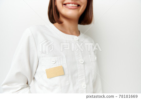 Soft focus on blank badge with space for text on white doctor's coat with beautiful smile Soft focus on blank badge with space for text on white doctor's coat with beautiful smile 78181669
