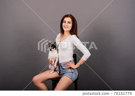 Young woman cuddling chihuahua puppy in studio Young woman cuddling chihuahua puppy in studio 78181779