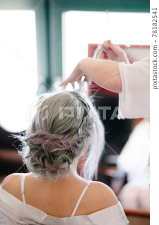 Hairdresser makes the bride an elaborate hairstyle. Close up Hairdresser makes the bride an elaborate hairstyle. Close up 78182541