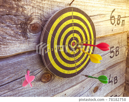 Large playable yellow and black dartboard or darts in the bar against the background of a wooden wall 78182758