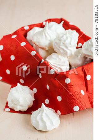 Small meringues meringue on a red background 78183319