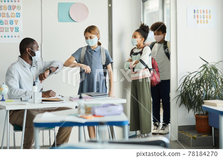 Teacher Safely Greeting Kids in Classroom 78184270