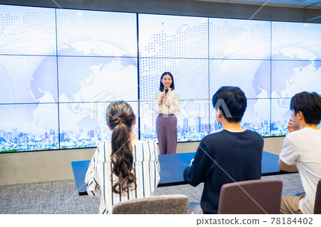 A young woman giving a presentation in front of a large vision A young woman giving a presentation in front of a large vision 78184402