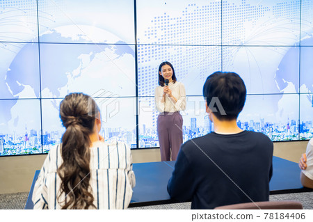 A young woman giving a presentation in front of a large vision A young woman giving a presentation in front of a large vision 78184406