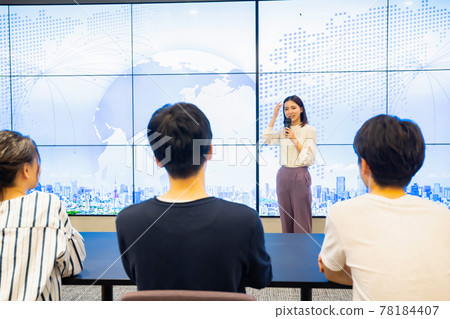 A young woman giving a presentation in front of a large vision A young woman giving a presentation in front of a large vision 78184407