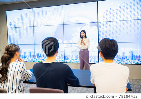 A young woman giving a presentation in front of a large vision A young woman giving a presentation in front of a large vision 78184412