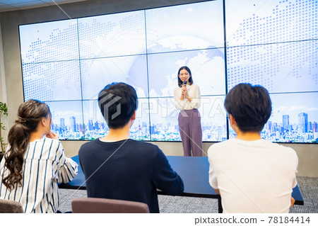 A young woman giving a presentation in front of a large vision A young woman giving a presentation in front of a large vision 78184414