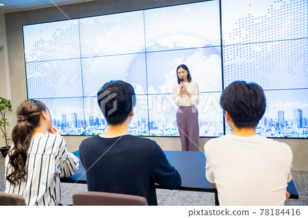 A young woman giving a presentation in front of a large vision A young woman giving a presentation in front of a large vision 78184416