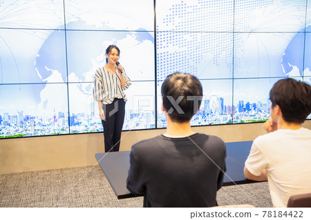 A young woman giving a speech in front of a large vision A young woman giving a speech in front of a large vision 78184422