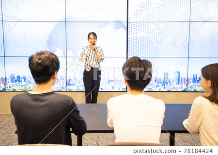 A young woman giving a speech in front of a large vision A young woman giving a speech in front of a large vision 78184424