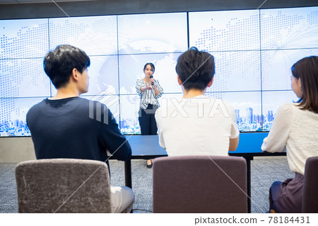 A young woman giving a speech in front of a large vision A young woman giving a speech in front of a large vision 78184431