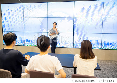 A young woman giving a speech in front of a large vision A young woman giving a speech in front of a large vision 78184435