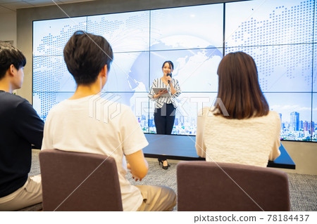 A young woman giving a speech in front of a large vision A young woman giving a speech in front of a large vision 78184437