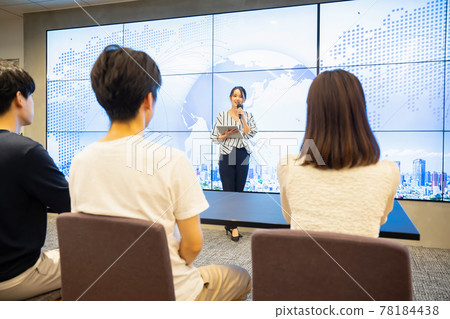 A young woman giving a speech in front of a large vision A young woman giving a speech in front of a large vision 78184438