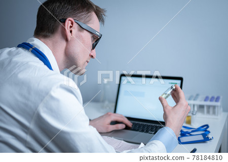 Scientist in medical laboratory examines vial of medicine, vaccine against viruses, influenza, covid. Doctor enters information into computer about investigation. Immunization from terrible diseases Scientist in medical laboratory examines vial of medicine, vaccine against viruses, influenza, covid. Doctor enters information into computer about investigation. Immunization from terrible diseases 78184810