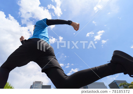 A young man jogging under the blue sky A young man jogging under the blue sky 78185372