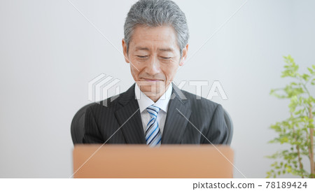 Image of an elderly businessman laughing 78189424