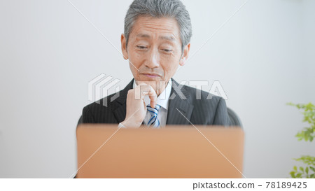 Image of an elderly businessman laughing 78189425