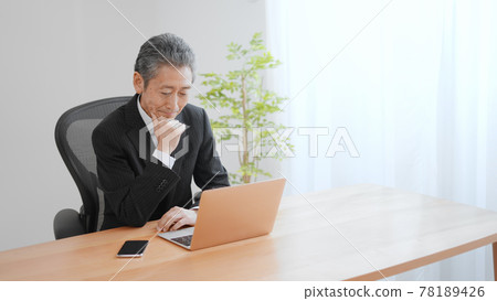 Image of an elderly businessman laughing 78189426