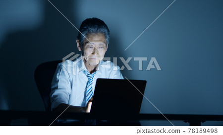 Image of an elderly businessman working overtime Image of an elderly businessman working overtime 78189498