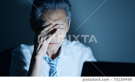 Image of an elderly businessman working overtime: sleepiness Image of an elderly businessman working overtime: sleepiness 78189499