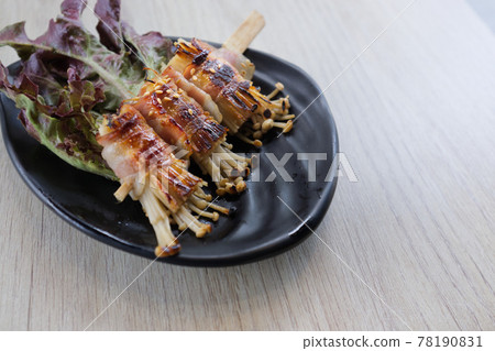 Roasted enoki mushrooms with bacon . Japanese food Roasted enoki mushrooms with bacon . Japanese food 78190831