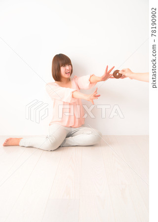 A young woman who is confused by being robbed of a snack A young woman who is confused by being robbed of a snack 78190902
