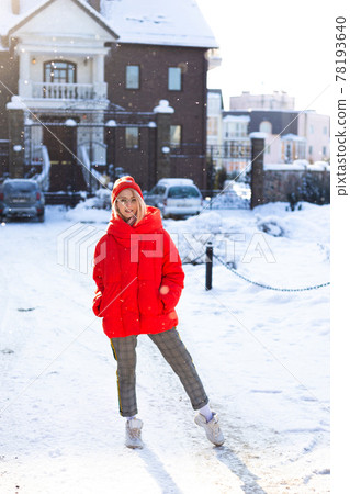Young stylish blonde woman on the street has fun, posing in snowy, frosty 78193640