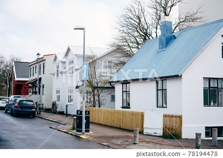 The facades of houses on the street in Reykjavik, the capital of Iceland. Several two-story houses and parked cars along the road. The facades of houses on the street in Reykjavik, the capital of Iceland. Several two-story houses and parked cars along the road. 78194478